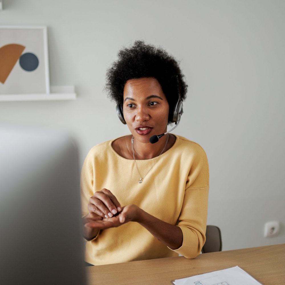 Mid adult female call center agent working at her desk in the office